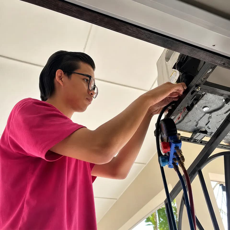 GenPlus technician diagnosing an opened wall-mounted air conditioner