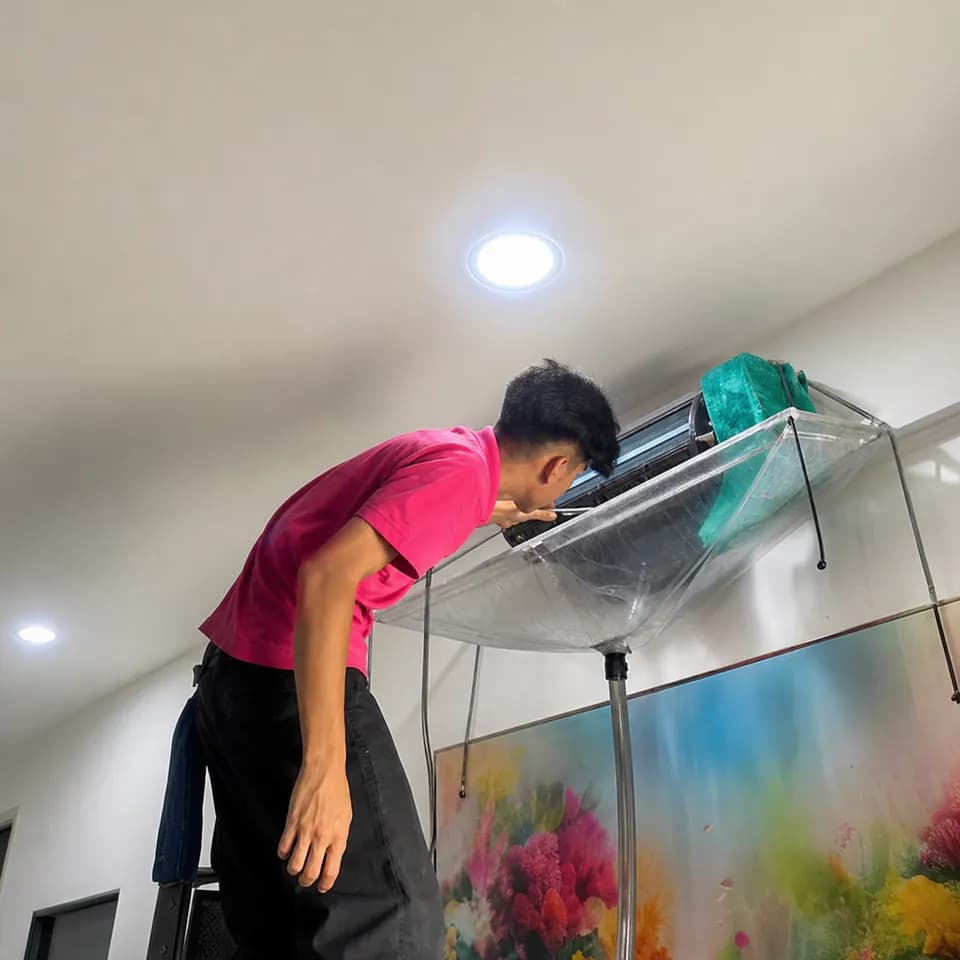 GenPlus technician carrying out protected aircond cleaning above an aquarium