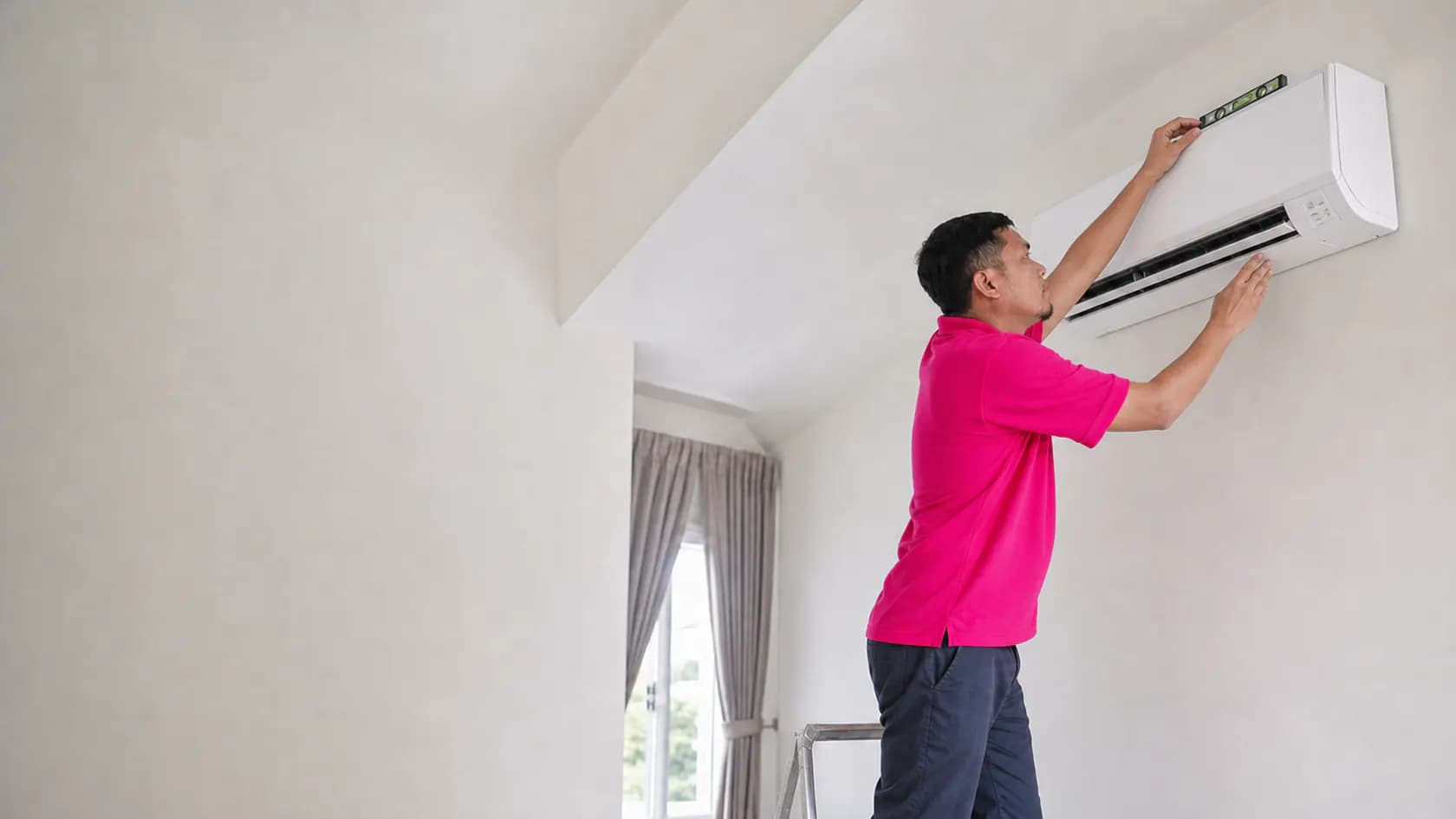 GenPlus technician checking the level of a newly installed air conditioner in Klang Valley
